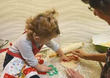 a woman and a little girl making dough